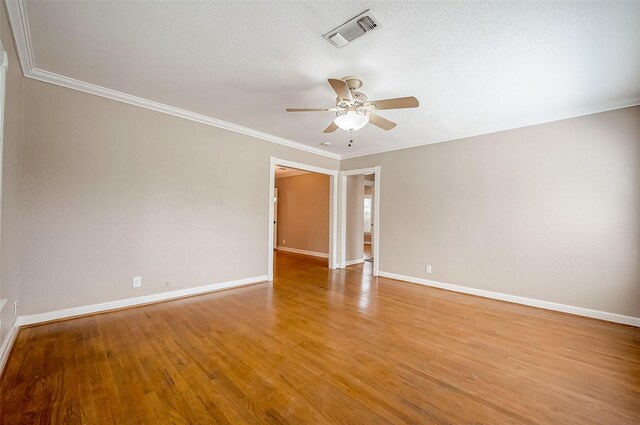 unfurnished room featuring light wood-type flooring, baseboards, visible vents, ceiling fan, and ornamental molding