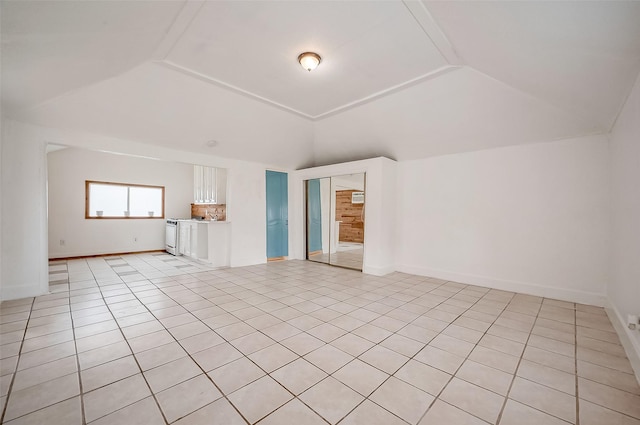 interior space with lofted ceiling, baseboards, and light tile patterned floors