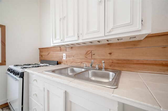 kitchen featuring white cabinets, a sink, and gas range gas stove