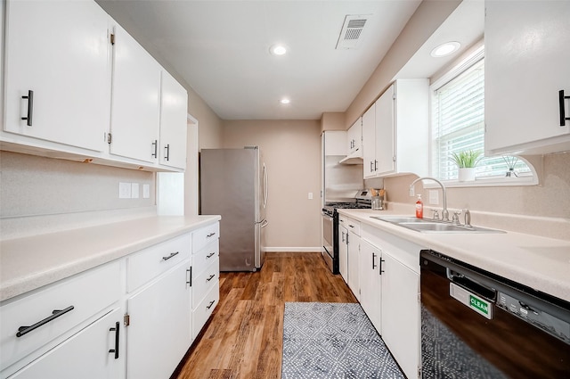 kitchen with white cabinets, visible vents, a sink, light wood-style floors, and appliances with stainless steel finishes