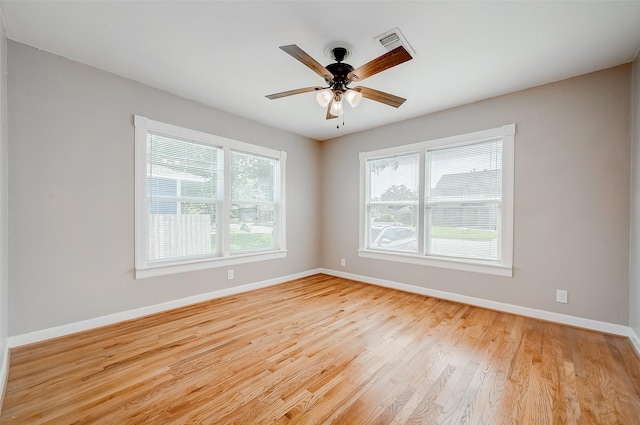 unfurnished room with ceiling fan, baseboards, light wood-style floors, and visible vents