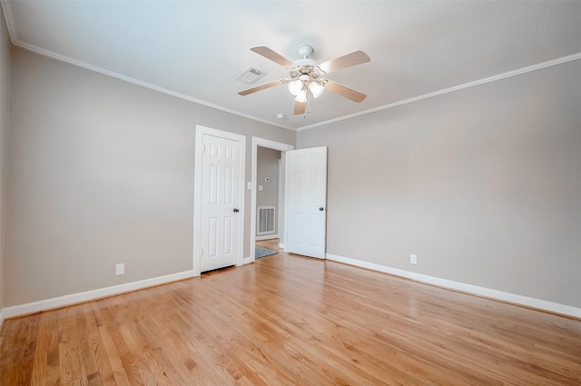 empty room featuring light wood finished floors, baseboards, a ceiling fan, and visible vents