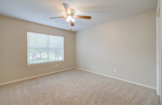 carpeted spare room with ceiling fan