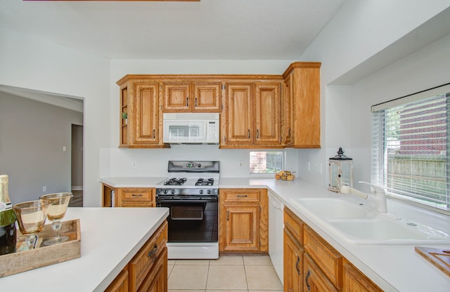 kitchen featuring sink, light tile patterned floors, and white appliances