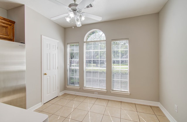 unfurnished dining area with light tile patterned flooring and ceiling fan