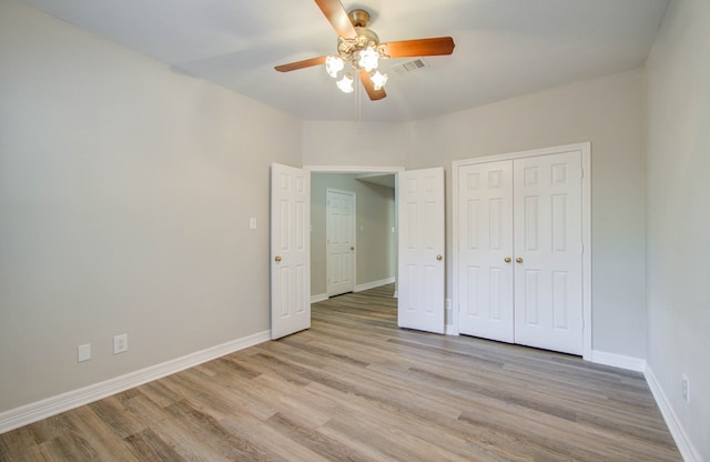 unfurnished bedroom featuring light hardwood / wood-style flooring, a closet, and ceiling fan