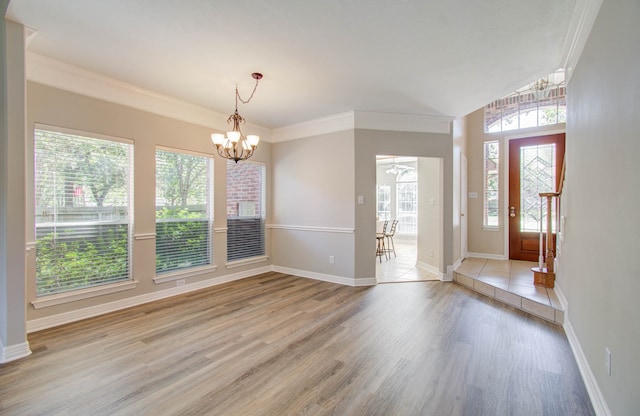 foyer featuring ornamental molding, an inviting chandelier, and light wood-type flooring