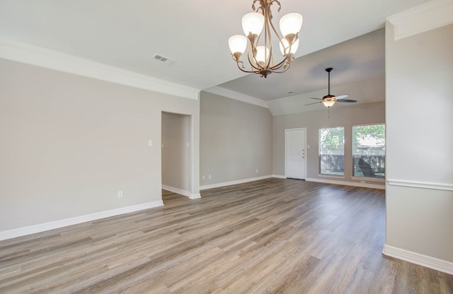 spare room featuring ornamental molding, ceiling fan with notable chandelier, light wood-type flooring, and vaulted ceiling