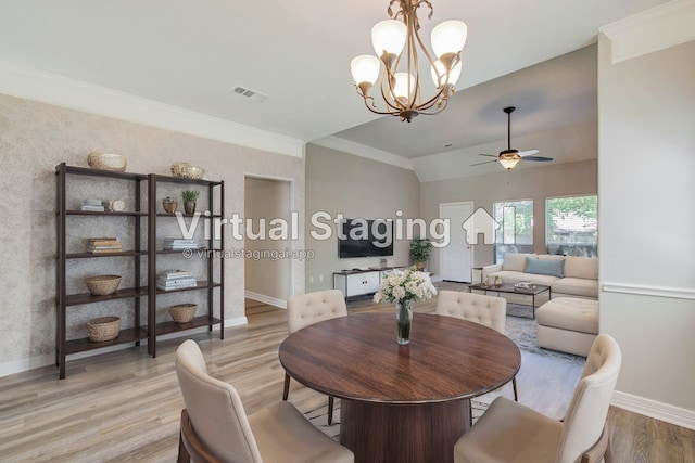 dining room featuring ornamental molding, ceiling fan with notable chandelier, light wood-type flooring, and vaulted ceiling