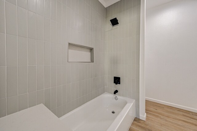 bathroom with tiled shower / bath and wood-type flooring