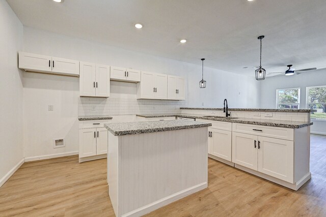 kitchen featuring light hardwood / wood-style floors, sink, pendant lighting, and a kitchen island