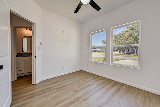 spare room with ceiling fan and light wood-type flooring