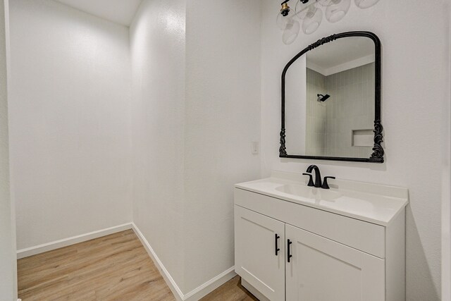 bathroom featuring vanity, walk in shower, and wood-type flooring