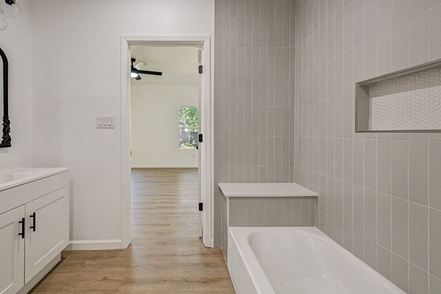 bathroom with vanity, wood-type flooring, and a washtub