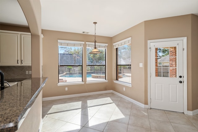 unfurnished dining area with a healthy amount of sunlight and light tile patterned flooring