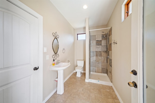 bathroom with tile patterned floors, toilet, and tiled shower