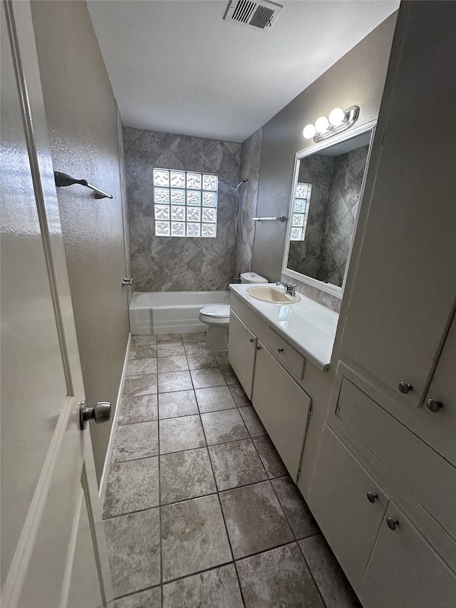 full bathroom featuring vanity, tiled shower / bath combo, and toilet