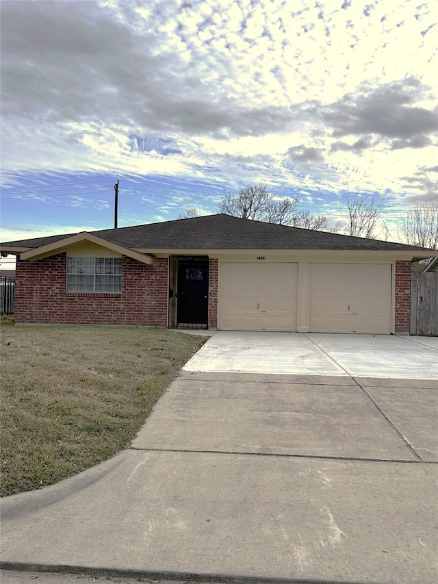 ranch-style house with a front yard and a garage