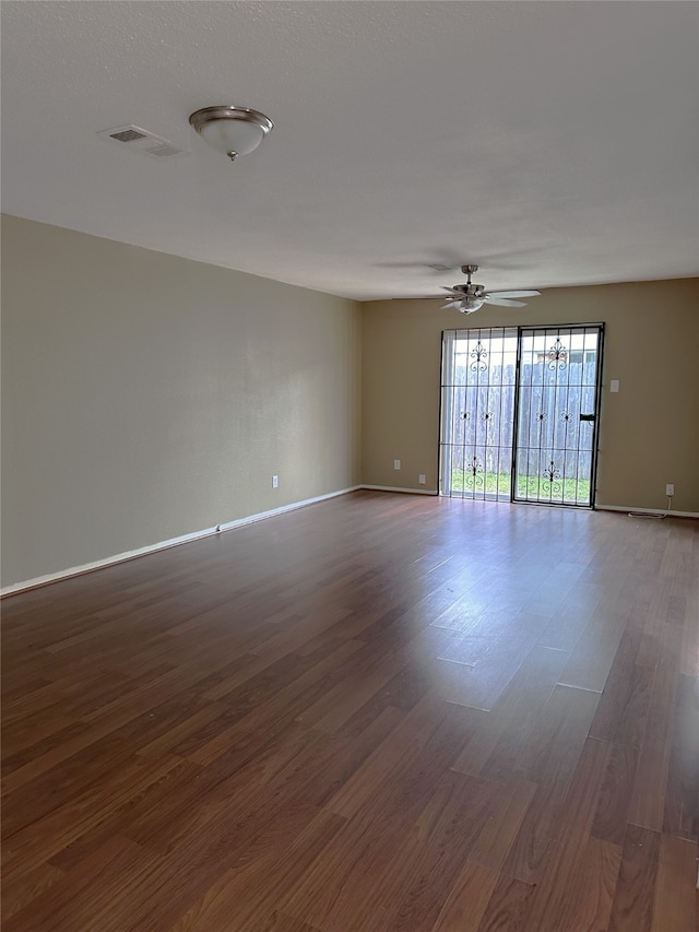 unfurnished room with ceiling fan and dark hardwood / wood-style flooring