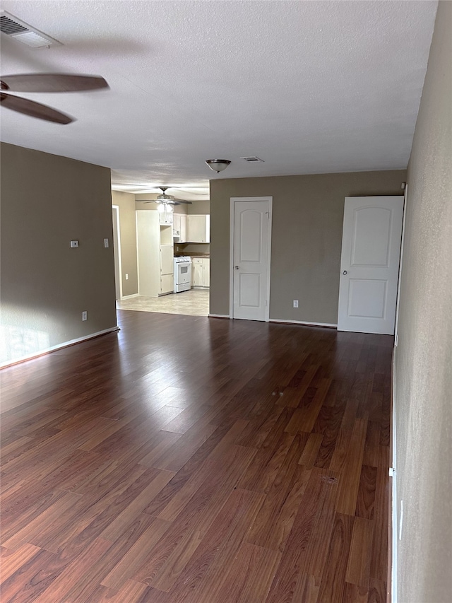 unfurnished living room featuring wood-type flooring and a textured ceiling