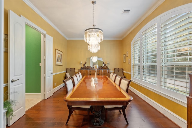 dining room with a notable chandelier, ornamental molding, and dark wood-type flooring