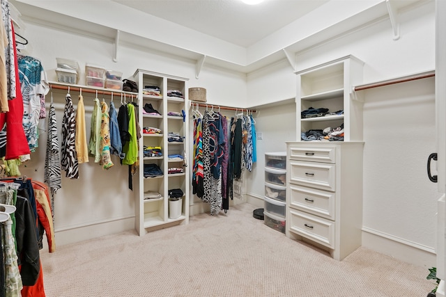 walk in closet with light carpet and beam ceiling