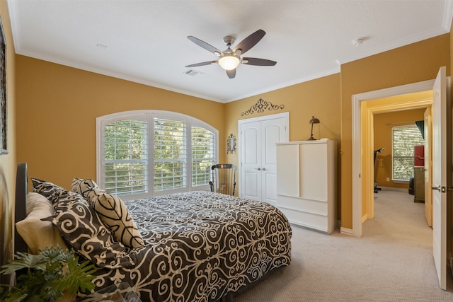 carpeted bedroom featuring a closet, ceiling fan, and crown molding