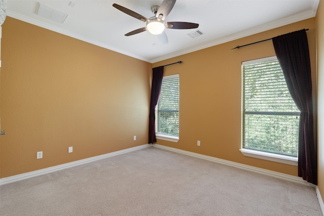 spare room with crown molding, light carpet, and a wealth of natural light