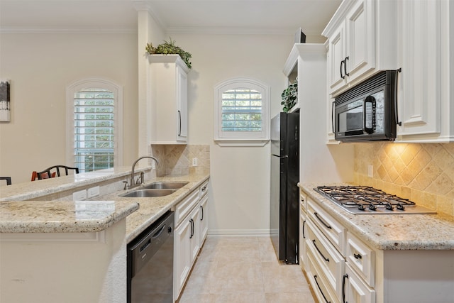 kitchen with kitchen peninsula, sink, black appliances, light stone countertops, and white cabinets