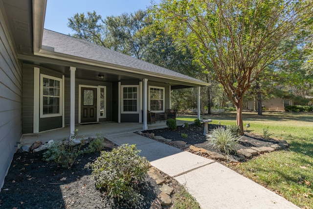 entrance to property featuring a porch and a yard