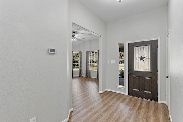 entryway with light hardwood / wood-style floors, lofted ceiling, and ceiling fan