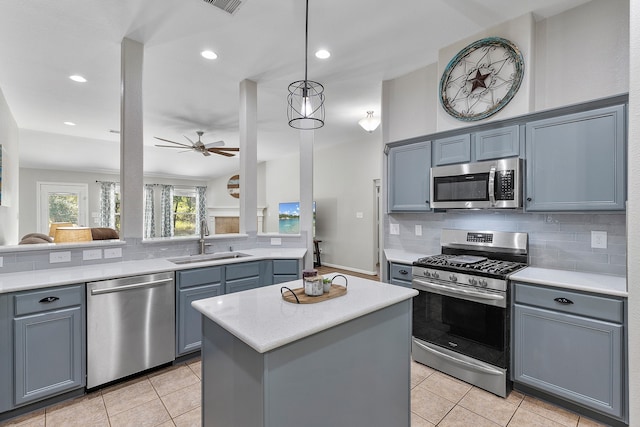 kitchen with tasteful backsplash, light tile patterned floors, a kitchen island, sink, and stainless steel appliances