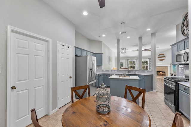 dining room with ceiling fan, light tile patterned floors, and a fireplace