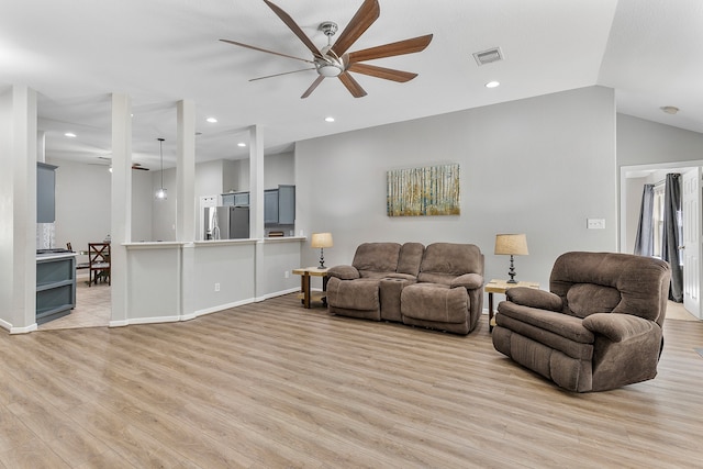 living room featuring ceiling fan, lofted ceiling, and light hardwood / wood-style flooring