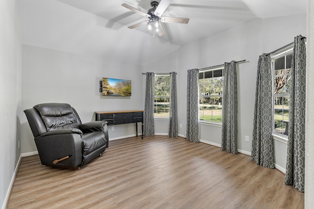 living area featuring hardwood / wood-style floors, vaulted ceiling, and ceiling fan