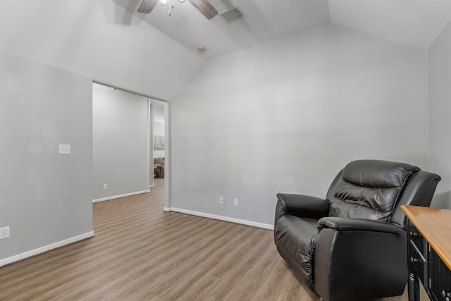 living area featuring vaulted ceiling, light wood-type flooring, and ceiling fan