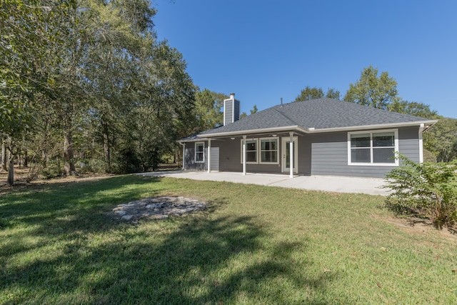 rear view of property featuring a yard and a patio