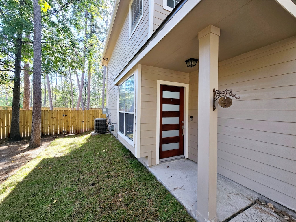 property entrance with a yard and central air condition unit