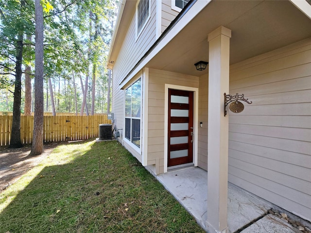 property entrance with a yard and central air condition unit