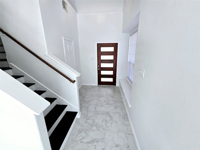 foyer featuring ornamental molding and a high ceiling