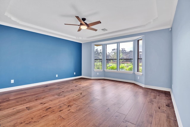 spare room featuring ceiling fan, a raised ceiling, ornamental molding, and hardwood / wood-style floors