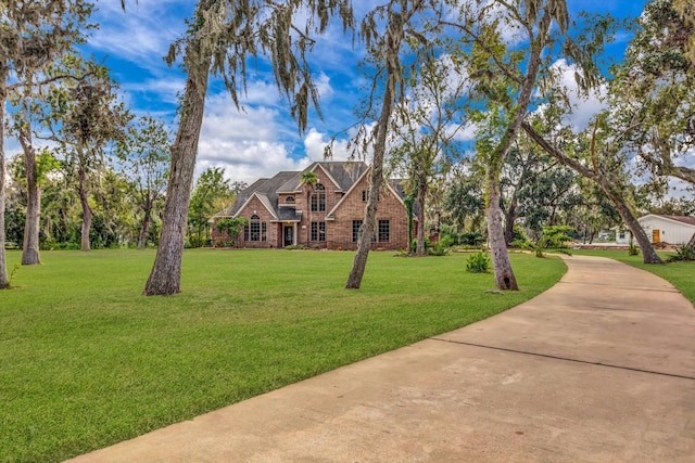 816 Lake Rd, Lake Jackson, TX 77566 - view of front of home with a front lawn, driveway, and brick siding