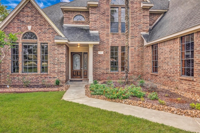 816 Lake Rd, Lake Jackson, TX 77566 - view of front of home with roof with shingles, brick siding, and a front lawn