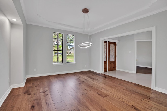 unfurnished room with ornamental molding, a notable chandelier, and wood-type flooring