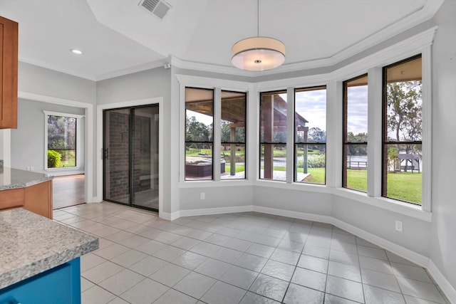 unfurnished dining area with crown molding, light tile patterned floors, and plenty of natural light