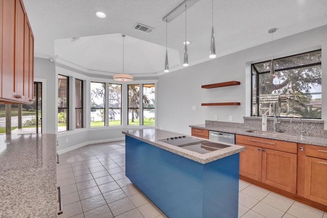 kitchen with a textured ceiling, a center island, decorative light fixtures, crown molding, and light tile patterned floors