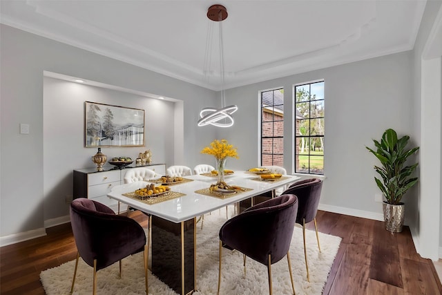 816 Lake Rd, Lake Jackson, TX 77566 - dining room with a raised ceiling, dark wood-style floors, baseboards, ornamental molding, and a chandelier