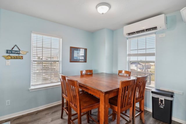 dining space featuring an AC wall unit, dark hardwood / wood-style floors, and a wealth of natural light