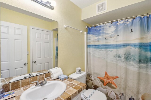 11218 Reagor Way, Galveston, TX 77554 - bathroom with vanity, toilet, and a shower with shower curtain