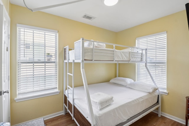 bedroom featuring hardwood / wood-style flooring and multiple windows